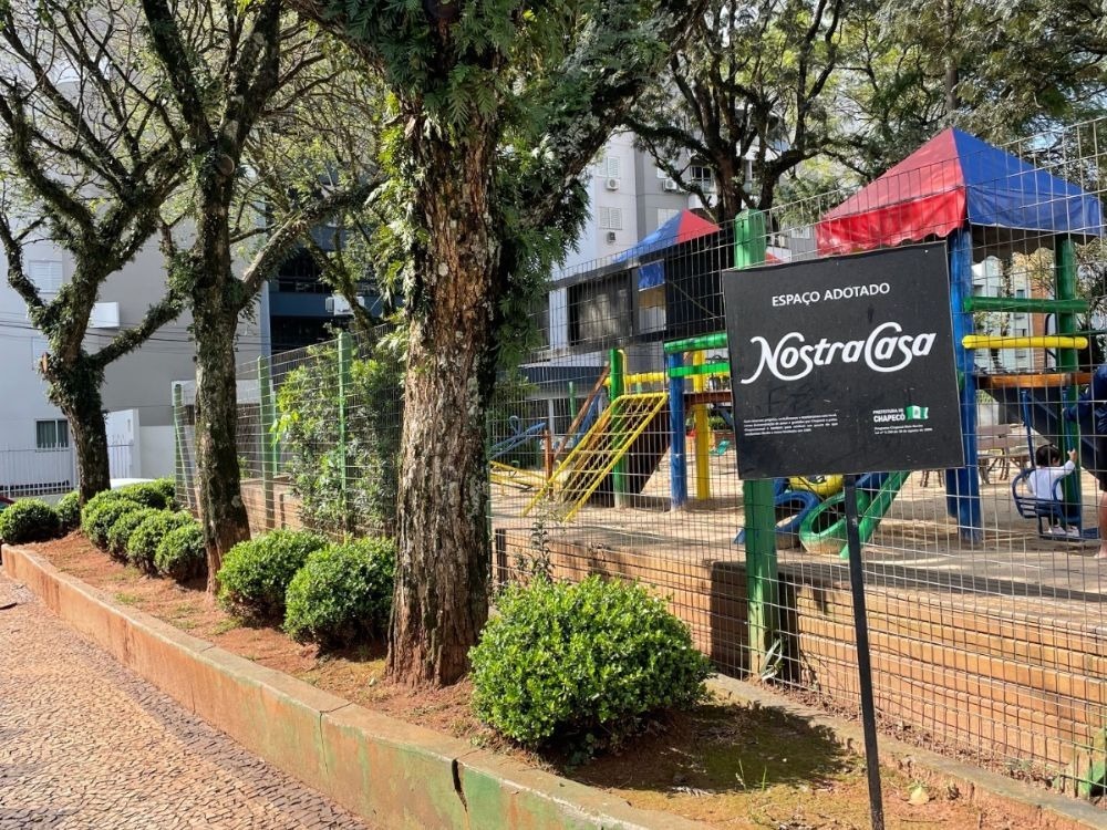 Praça com playground, árvores e área urbana estruturada, cenário comum para quem busca morar em frente ao Colégio Marista Chapecó