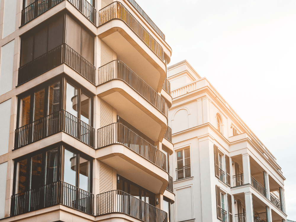 Fachadas de dois edifícios residenciais modernos, com varandas e janelas envidraçadas, representando oportunidades no mercado imobiliário.